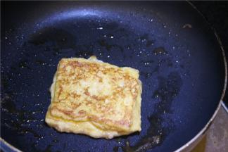 锅中放入1块黄油，油化开转中火，放上吐司片慢煎