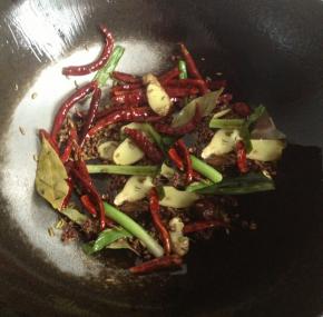 锅内放油，油热之后放入干辣椒，葱姜和所有的香料小火炒出香味