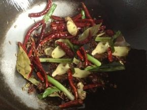 锅内放油，油热之后放入干辣椒，葱姜和所有的香料小火炒出香味