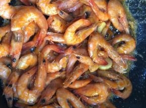倒入炸好的明虾。倒入生抽，料酒，蚝油和少许的盐，翻炒均匀