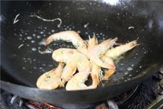 然后倒入鲜虾翻炒，使其变色