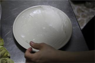 将过水后的春卷皮平铺在一张盘子上