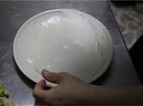 将过水后的春卷皮平铺在一张盘子上