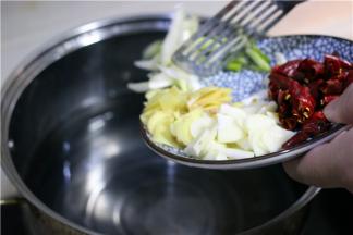 鱼切片，鱼头切两半，鱼骨鱼片分开装，准备好上述原料，准备好一个大锅，倒入开水，加少许大葱段煮开。