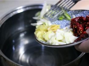 鱼切片，鱼头切两半，鱼骨鱼片分开装，准备好上述原料，准备好一个大锅，倒入开水，加少许大葱段煮开。