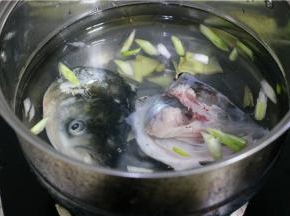 左边的水锅先倒入鱼头，略煮2分钟，等水开。