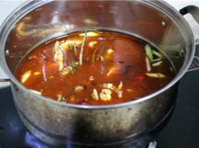 把鱼骨同香料一起翻炒出香，稍后加入肥肠翻炒。