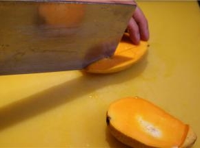 先把芒果切成两半，用刀在芒果果肉上划成9宫格，然后把果皮翻转，用刀切掉果皮。