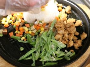 平底锅烧热，倒入少许橄榄油，放入青豆、玉米和胡萝卜，少许过油