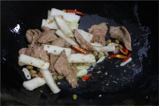 再倒入事先滑炒过的年糕，牛肉