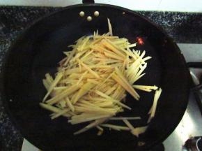 肉丝6成熟时放上土豆丝，大火翻炒