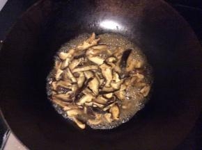 用锅中剩余的油炒香菇片，加入适量的水烹炒
