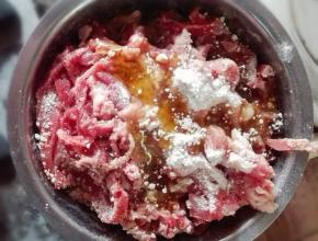 瘦肉洗净切丝，加入适量生粉和1个鸡蛋，抓揉均匀