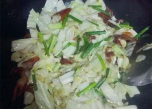 油锅加热，将生姜碎和腊肉倒入锅中翻炒，炒到5~6成熟时放入卷心菜翻炒，撒上葱段