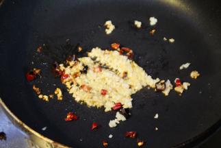 炸好的排骨装盘沥油，锅中再放入少许油，加蒜蓉、干辣椒末炒香，放上炸好的排骨翻炒3-5分钟，让蒜蓉均匀的粘在排骨上