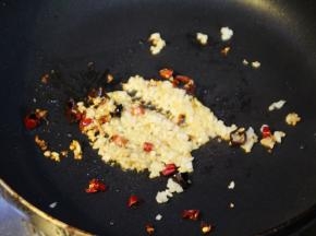 炸好的排骨装盘沥油，锅中再放入少许油，加蒜蓉、干辣椒末炒香，放上炸好的排骨翻炒3-5分钟，让蒜蓉均匀的粘在排骨上