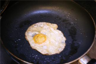 平底锅中放上一小块黄油，磕一颗鸡蛋，小火慢煎成型