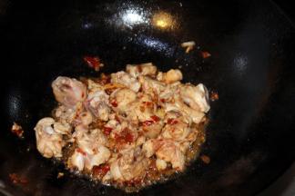 准备一口干净的炒锅，倒上食用油，油开后转小火把鸡肉下到锅里翻炒，同时倒上豆瓣酱和生姜块