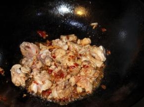 准备一口干净的炒锅，倒上食用油，油开后转小火把鸡肉下到锅里翻炒，同时倒上豆瓣酱和生姜块
