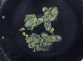 锅中剩少油，倒入姜片和黄瓜片翻炒