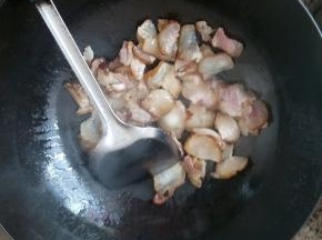 锅中倒入适量的油，烧热后转中火放入腊肉爆香，再放上蒜片和干辣椒炒香