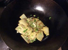土豆片炒熟加盐和孜然粉调味增香，撒上葱花出锅