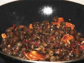 加入田螺，一大勺郫县豆瓣，料酒少许，继续翻炒；加入少许糖，味极鲜，翻炒均匀后加一碗水煮炖入味，汤汁浓稠后收汁出锅