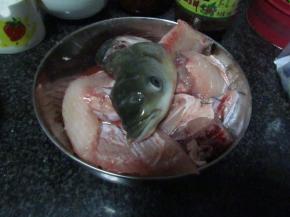 草鱼洗净去鳞，鱼头对半剖开，鱼身切片