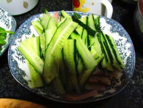 把切好的猪肉铺放在盘底，上面放上黄瓜片