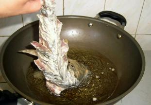 油锅烧至6成热，开小火把鲤鱼放入锅中炸透