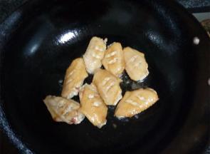 锅中热油，把处理好的鸡翅放入锅中翻炒，炒至表皮金黄