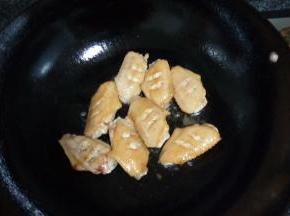 锅中热油，把处理好的鸡翅放入锅中翻炒，炒至表皮金黄