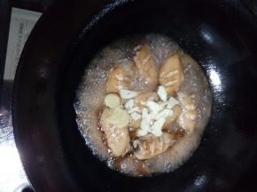 鸡翅炒6分熟后，倒入可乐，放上葱蒜片，加盖大火焖煮