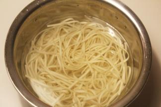 锅里烧水，水煮开后放上面条煮熟捞出，放在凉水中浸泡，用筷子搅拌，防止面条粘连