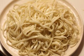 面条凉透后淋上少许香油，铺在盘子上