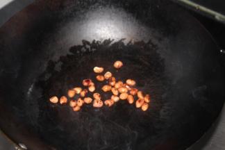 炒锅少油，放上花生翻炒，用瓶子碾压成碎