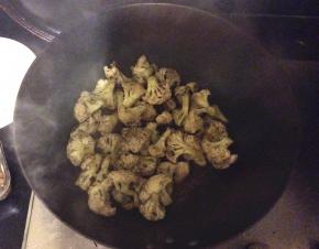 把花菜倒入锅中翻炒，加上少许的五香粉、辣椒粉、花椒粉入味