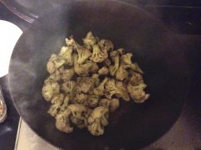 把花菜倒入锅中翻炒，加上少许的五香粉、辣椒粉、花椒粉入味