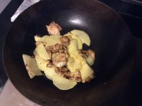 加入土豆片一同炒，炒熟后加盐、孜然粉调味