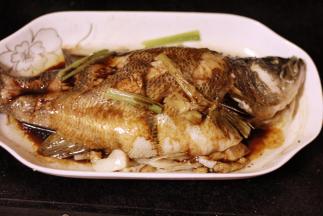 蒸好的鱼放在一旁，用锅铲按住鱼身，倒掉盘子中的水，另取一口干净的锅，倒上1碗酱油，大火烹煮30秒，淋在鱼身上；再往锅中倒上半碗油，油开后淋在鱼身，最后撒上葱花就好了