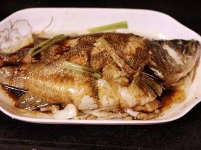 蒸好的鱼放在一旁，用锅铲按住鱼身，倒掉盘子中的水，另取一口干净的锅，倒上1碗酱油，大火烹煮30秒，淋在鱼身上；再往锅中倒上半碗油，油开后淋在鱼身，最后撒上葱花就好了