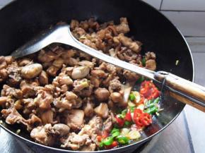 利用锅中的底油，放入葱段、姜片、干辣椒爆炒，变色后放入兔肉翻炒，接着加入料酒、适量生抽、糖和盐调味上色