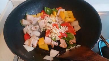 倒入各色彩椒，翻炒几下加蒜末出香