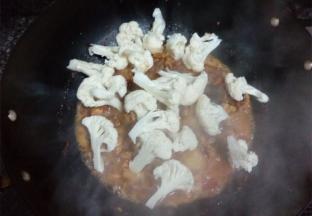 水煮开后把花菜倒入锅中，放入适量的盐，大火煮开，转中小火焖煮