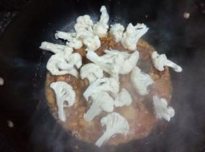 水煮开后把花菜倒入锅中，放入适量的盐，大火煮开，转中小火焖煮