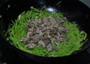 青笋丝炒至断生放盐入味，加入瘦肉丝翻炒