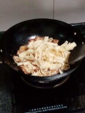 五花肉煸干后，把面皮倒进锅中混炒