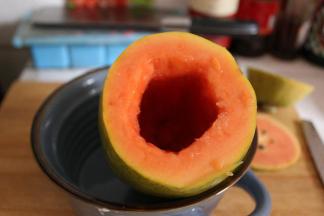 木瓜的四分之一处用刀切开，用长一点勺子将里面的籽全部抠出，挖的时候尽量让内壁比较平滑