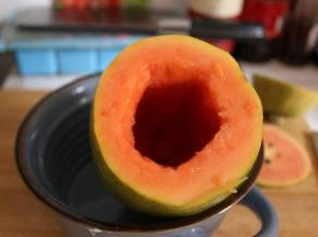 木瓜的四分之一处用刀切开，用长一点勺子将里面的籽全部抠出，挖的时候尽量让内壁比较平滑