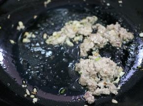 锅内底油烧热，倒入葱姜蒜末，炒出香味。放入肉末，炒至变色